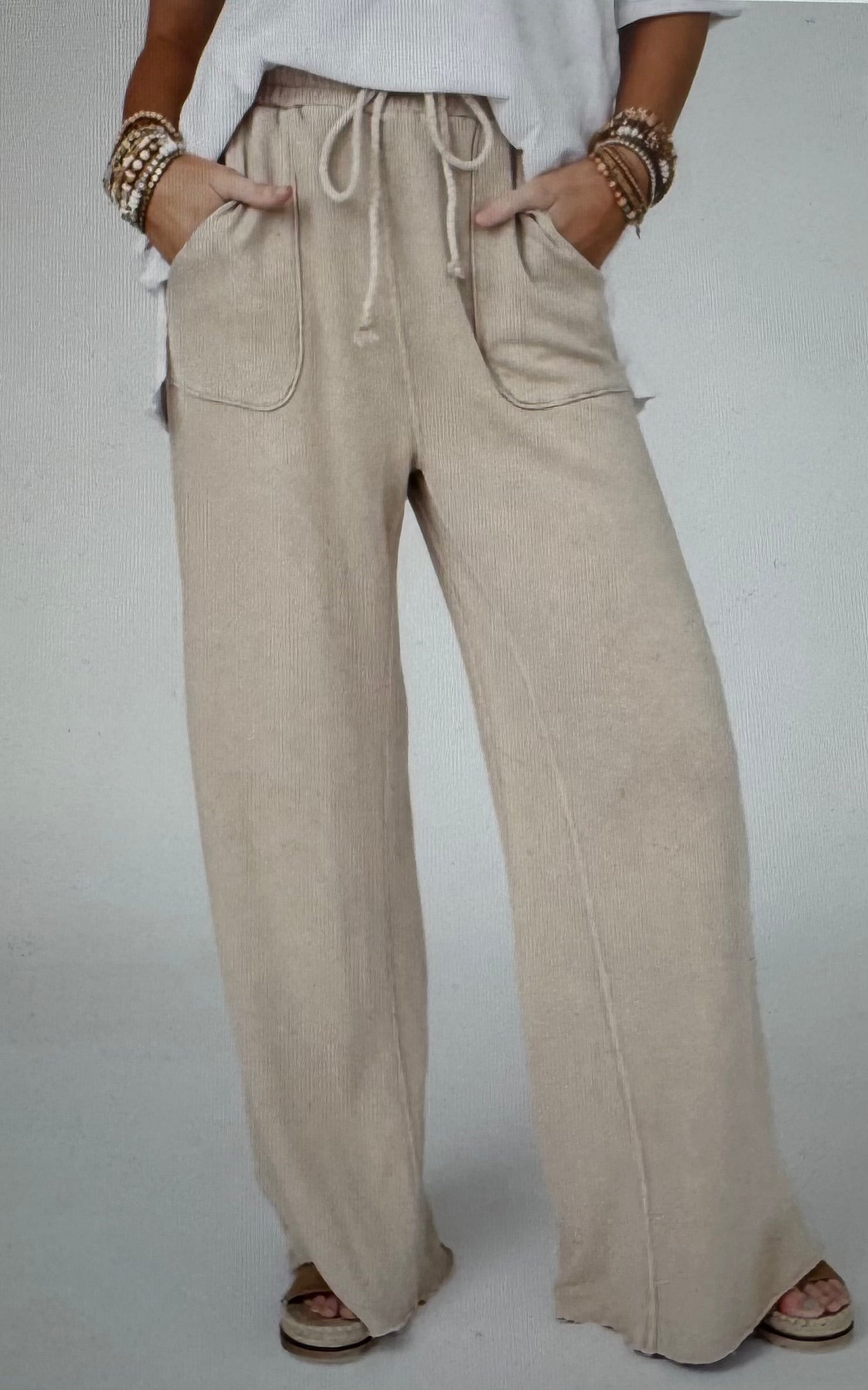 Beige wide-leg pants worn by a person on a plain background