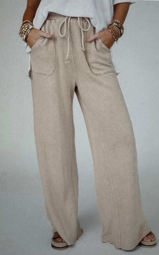Beige wide-leg pants worn by a person on a plain background
