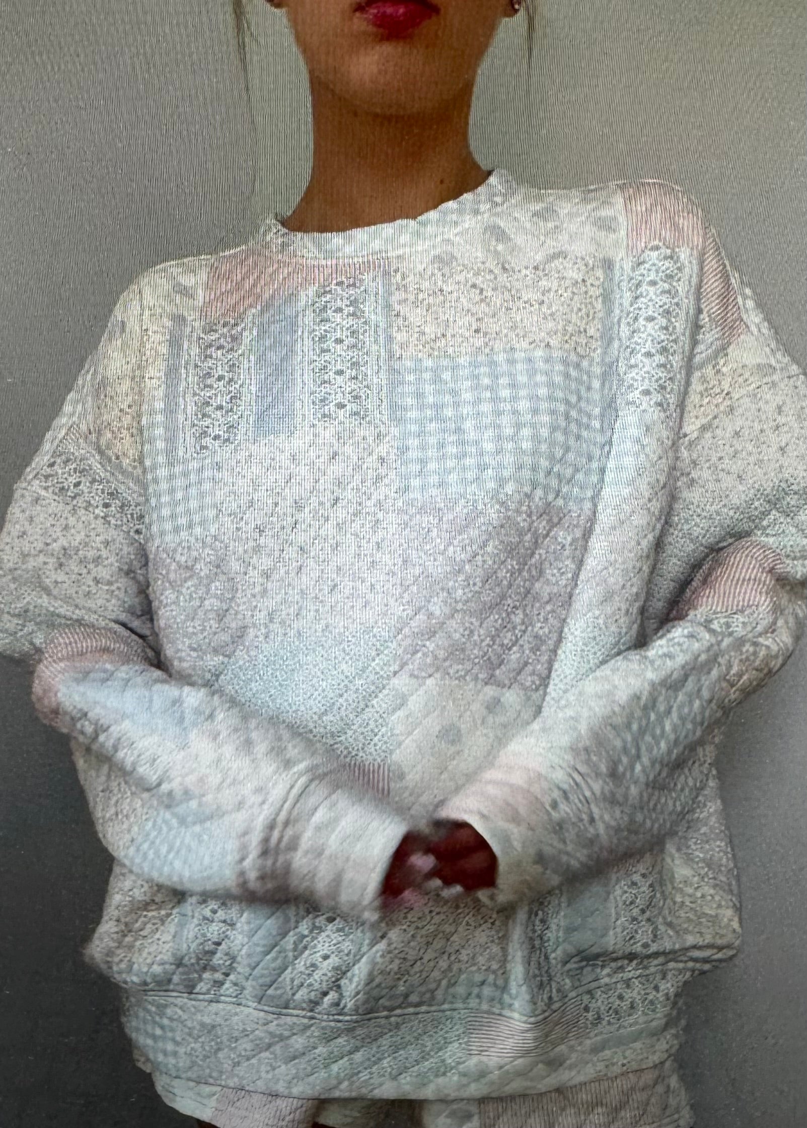 Person wearing a textured sweater with a neutral background