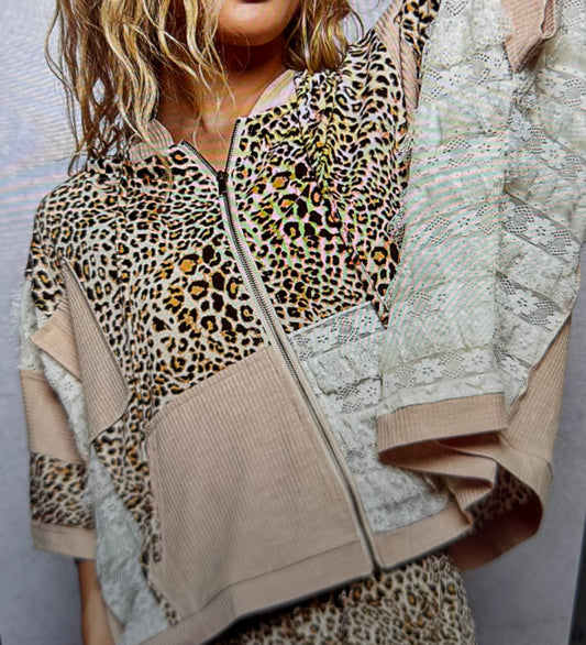 woman wearing a leopard & lace top with gray background