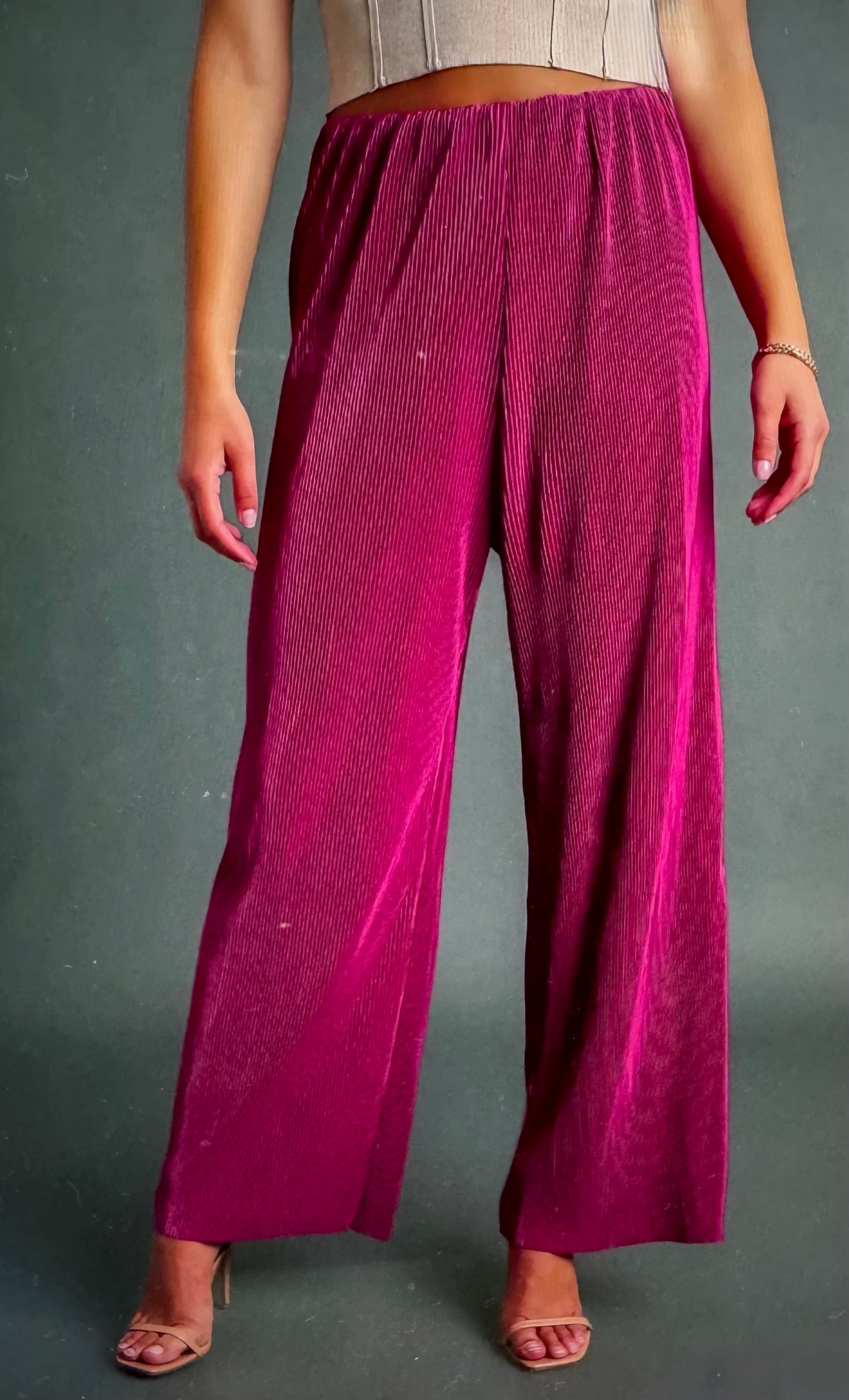 Person wearing magenta wide-leg pants on a gray background