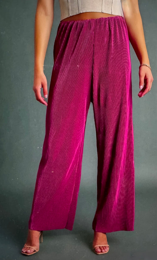 Person wearing magenta wide-leg pants on a gray background